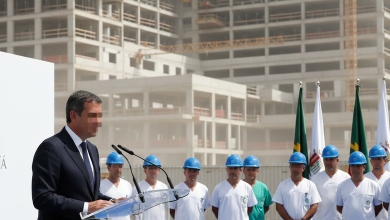 Juanma Moreno en un acto sanitario en Andalucía con obras de hospital de fondo.